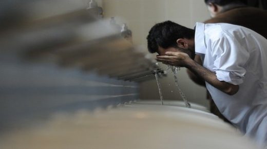 A Muslim man performs the religious ritual of ablution before Friday prayers in Baitul Futuh Mosque in south London, on February 18, 2011. The prayers also incorporated a Unite Against Extremism call at Western Europe's largest mosque. AFP PHOTO/CARL COURT (Photo credit should read CARL COURT/AFP/Getty Images)